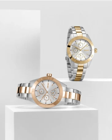 Imagem com dois relógios DKNY, modelos de caixa redonda, com bracelete bicolor prateada e dourada.